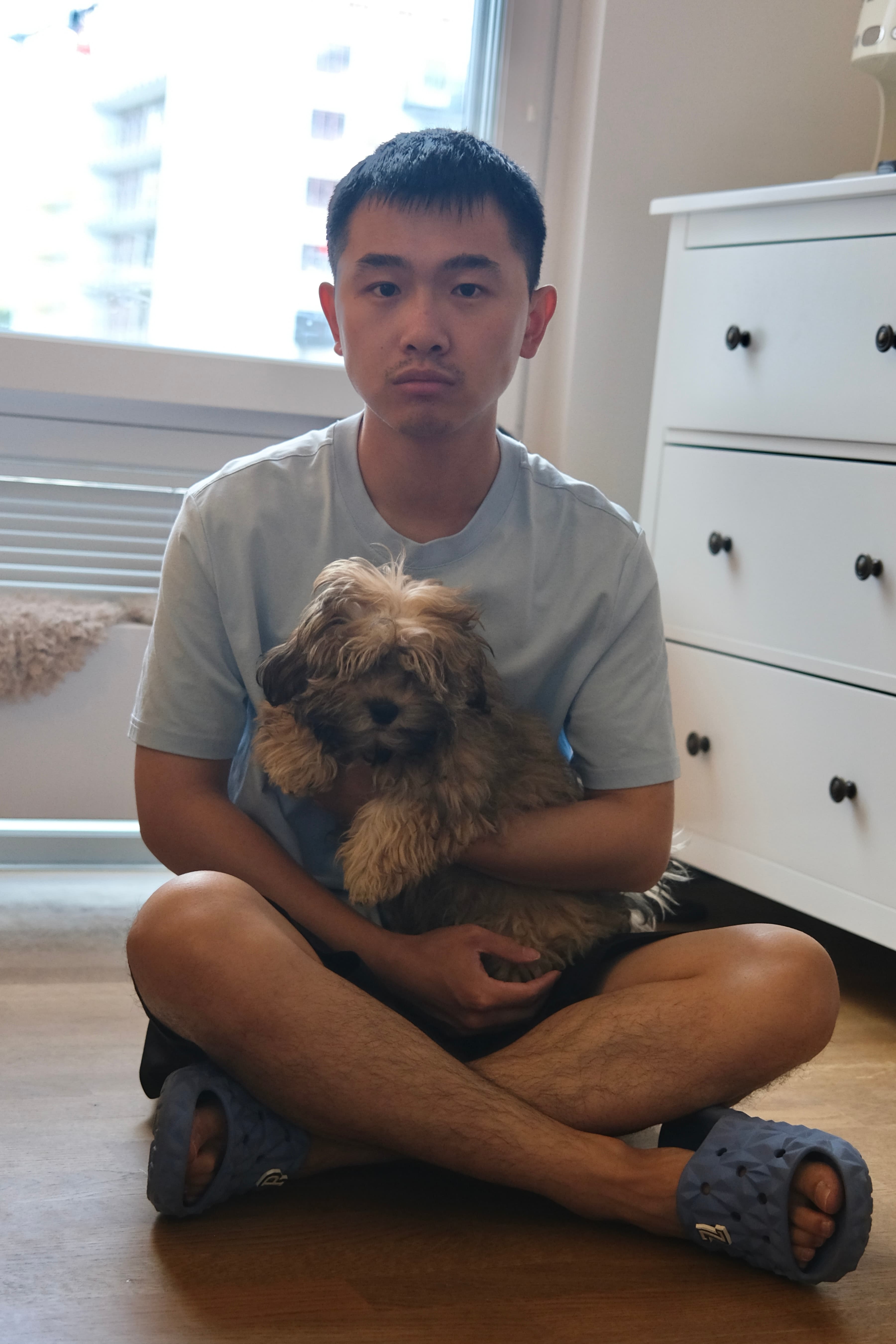 Evan calmly holding a puppy during an individual dog training interaction