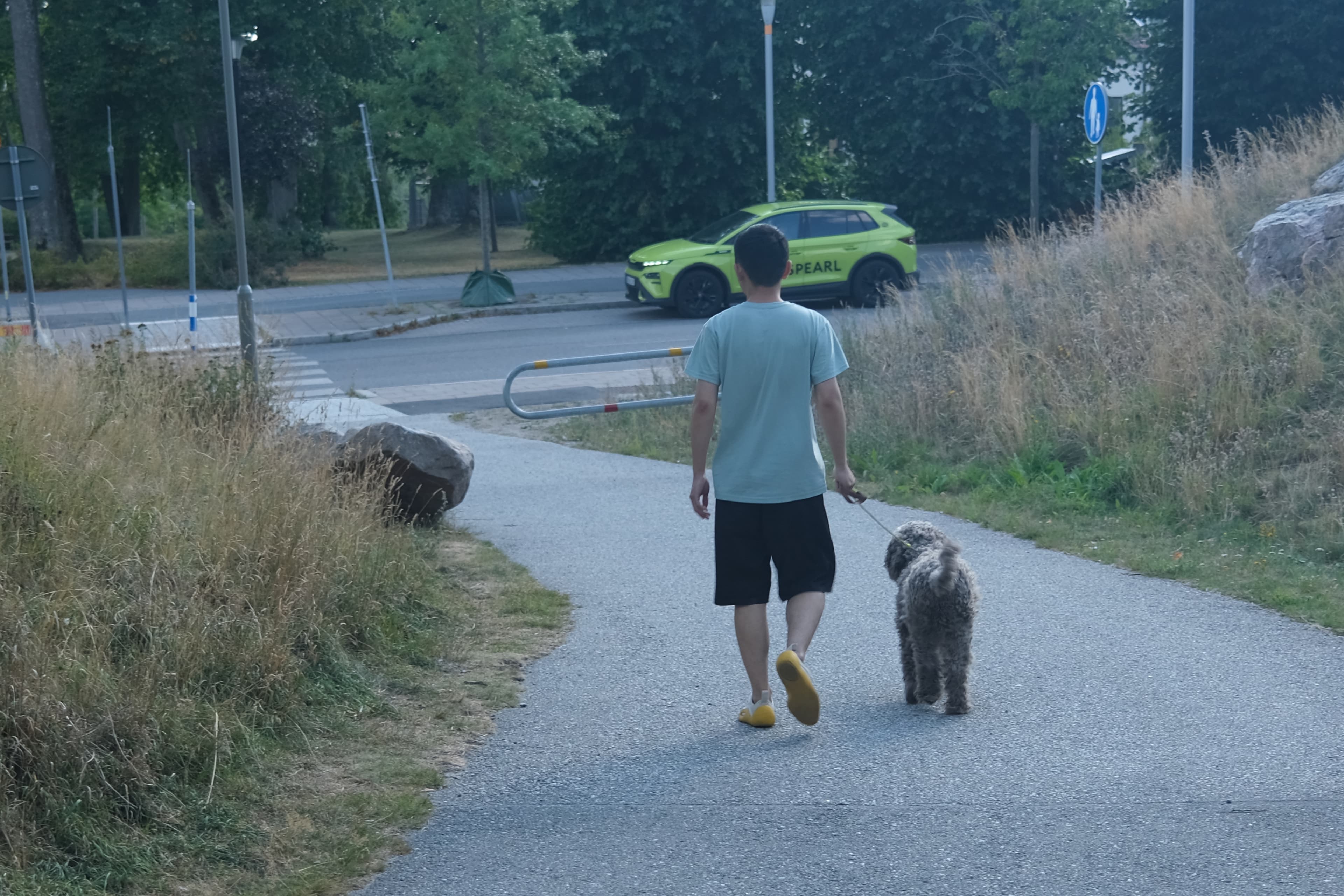 Evan walking Jum Jum along a quiet path in Stockholm